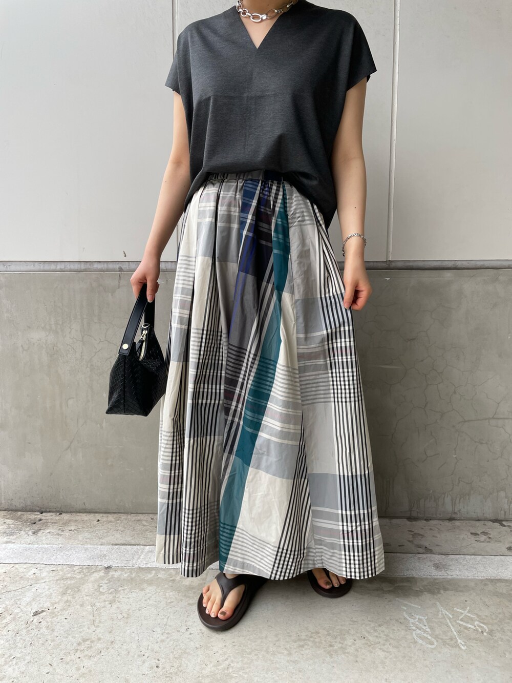 グレー系のTシャツ/カットソー、ブルー系のスカート、ブラウン系のサンダルを着用したレディースの春コーディネートの3枚目の写真