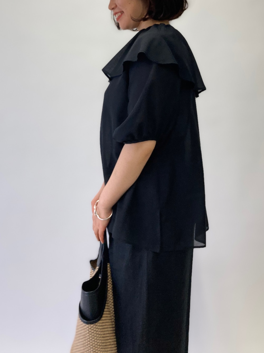 ブラック系のシャツ/ブラウス、ブラック系のかごバッグ、ブラック系のパンプスを着用したレディースの春コーディネートの4枚目の写真