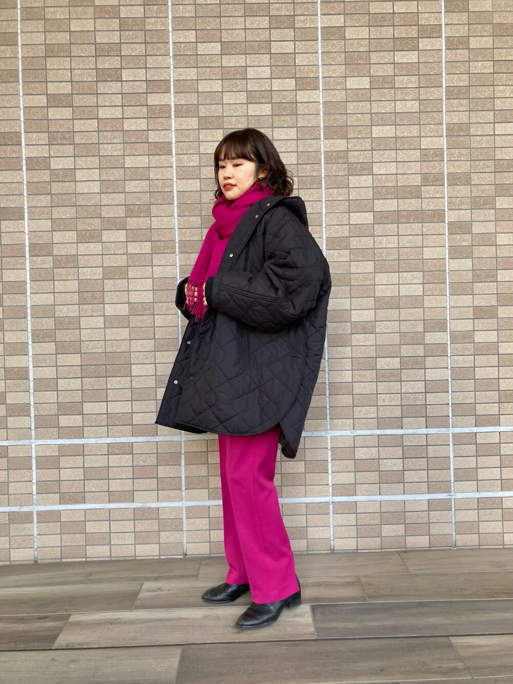 ブラック系のダウンジャケット/コート、ベージュ系のニット/セーター、ピンク系のその他パンツを着用したレディースの冬コーディネートの2枚目の写真