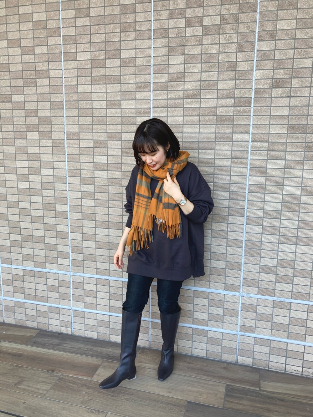 グレー系のTシャツ/カットソー、ブラック系のデニムパンツ、ブラック系のブーツを着用したレディースの冬コーディネートの3枚目の写真