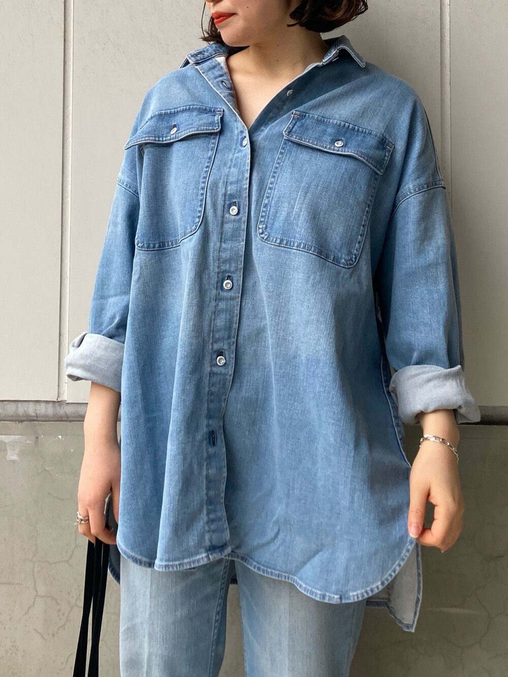 ブルー系のシャツ/ブラウス、ブルー系のデニムパンツ、ブラック系のトートバッグを着用したレディースの冬コーディネートの3枚目の写真