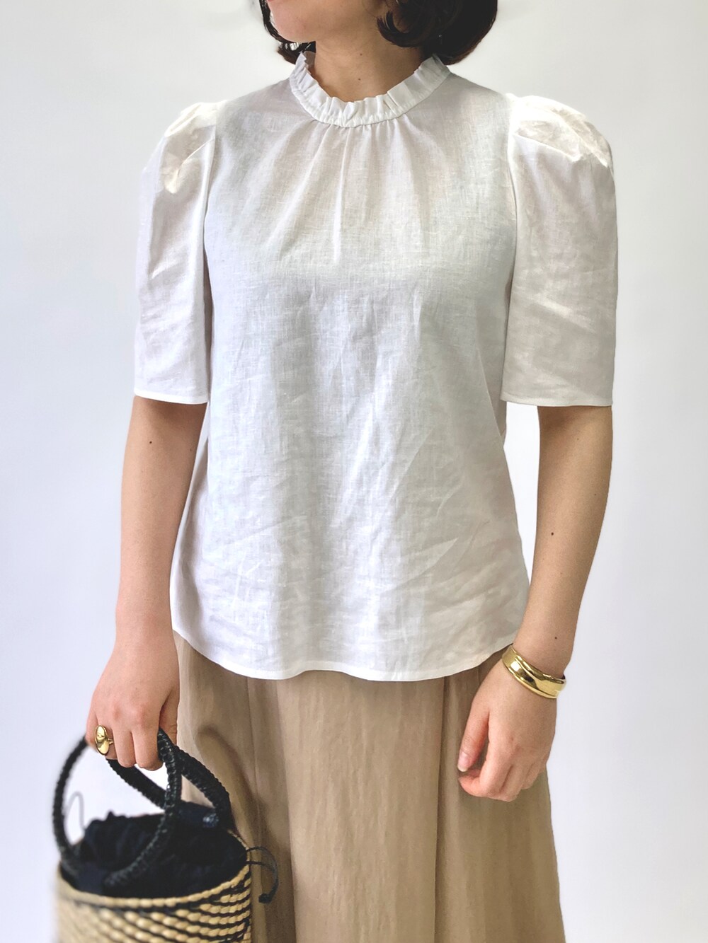 ホワイト系のシャツ/ブラウス、ベージュ系のスカート、ベージュ系のかごバッグを着用したレディースの春コーディネートの4枚目の写真