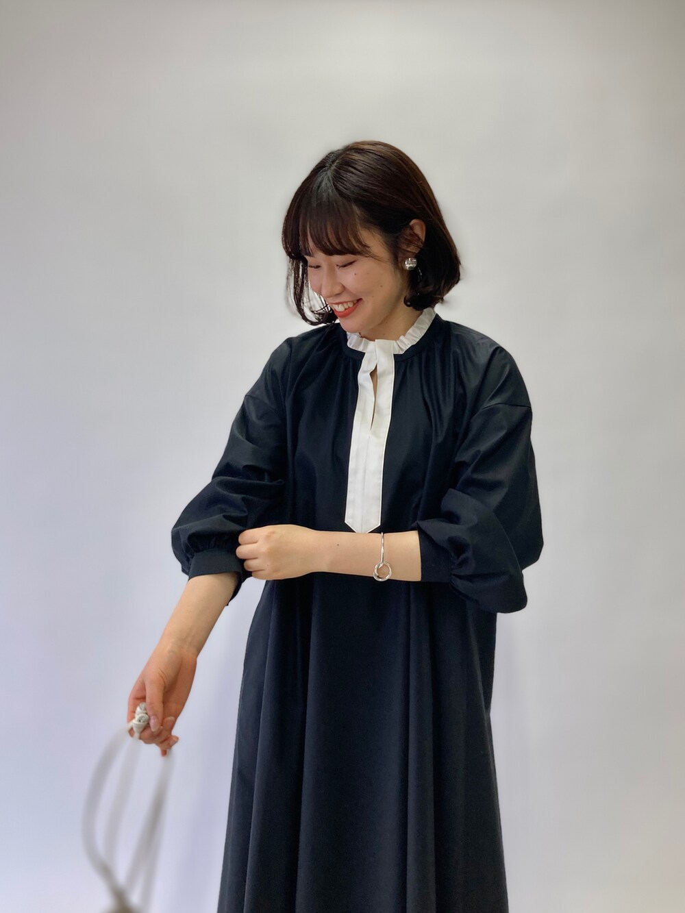 ブラック系のワンピース、ホワイト系のショルダーバッグ、ブラウン系のサンダルを着用したレディースの春コーディネートの3枚目の写真