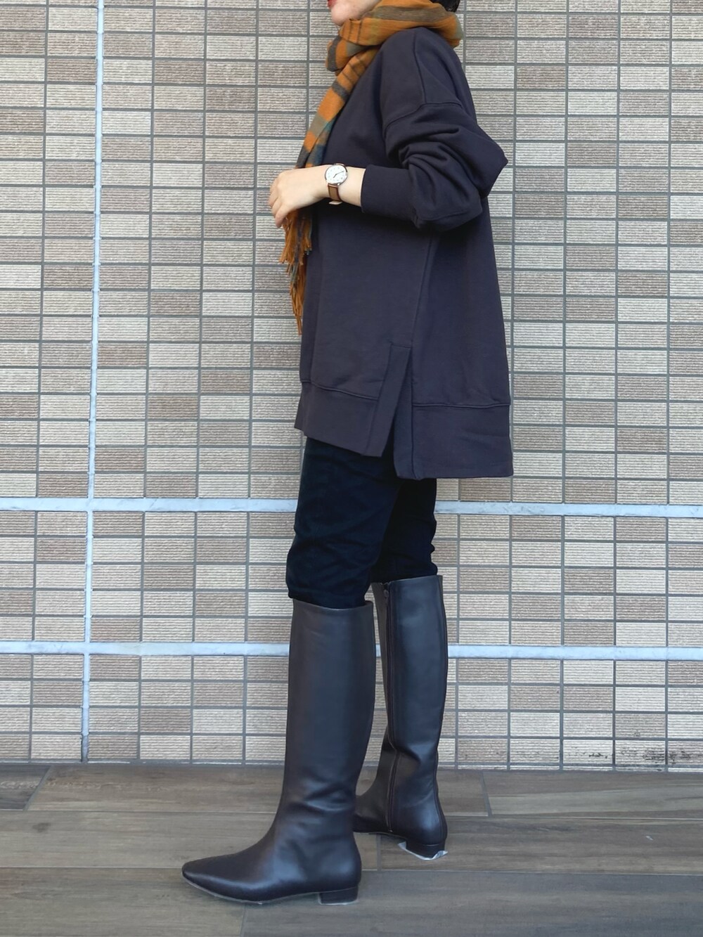 グレー系のTシャツ/カットソー、ブラック系のデニムパンツ、ブラック系のブーツを着用したレディースの冬コーディネートの2枚目の写真