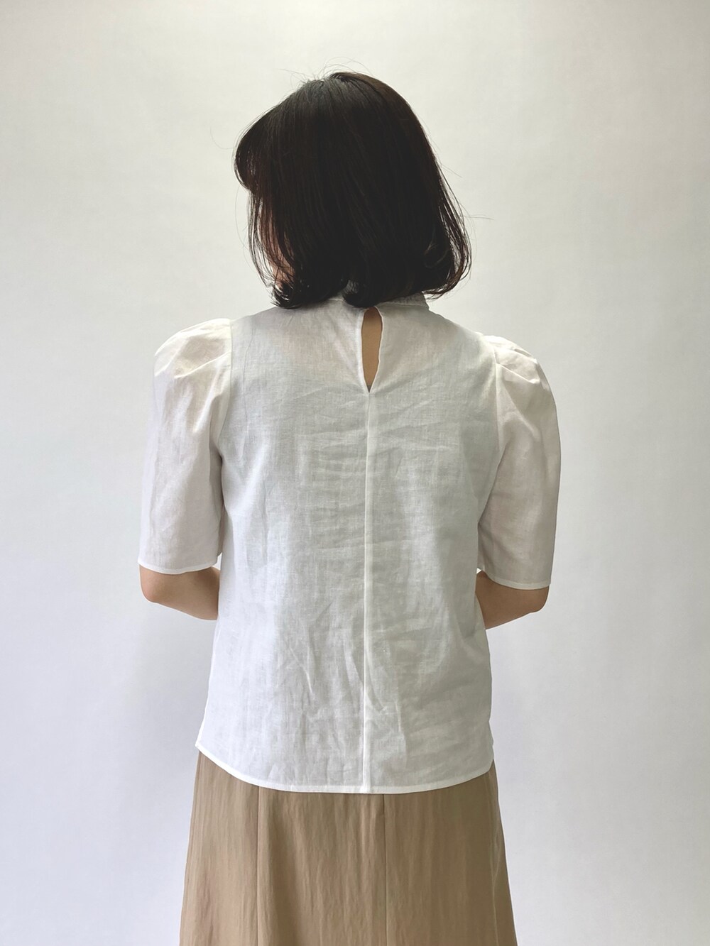 ホワイト系のシャツ/ブラウス、ベージュ系のスカート、ベージュ系のかごバッグを着用したレディースの春コーディネートの5枚目の写真