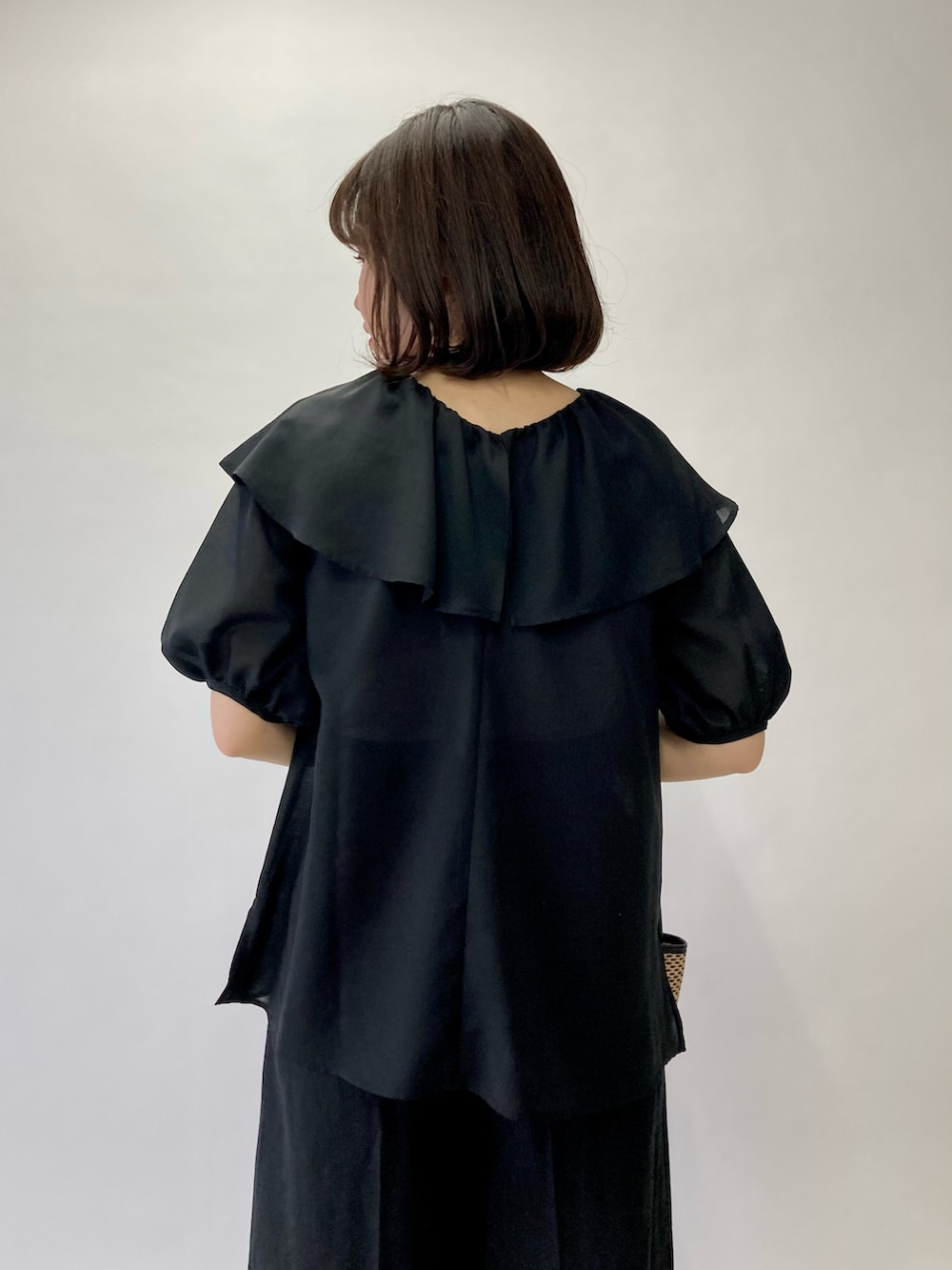 ブラック系のシャツ/ブラウス、ブラック系のかごバッグ、ブラック系のパンプスを着用したレディースの春コーディネートの5枚目の写真