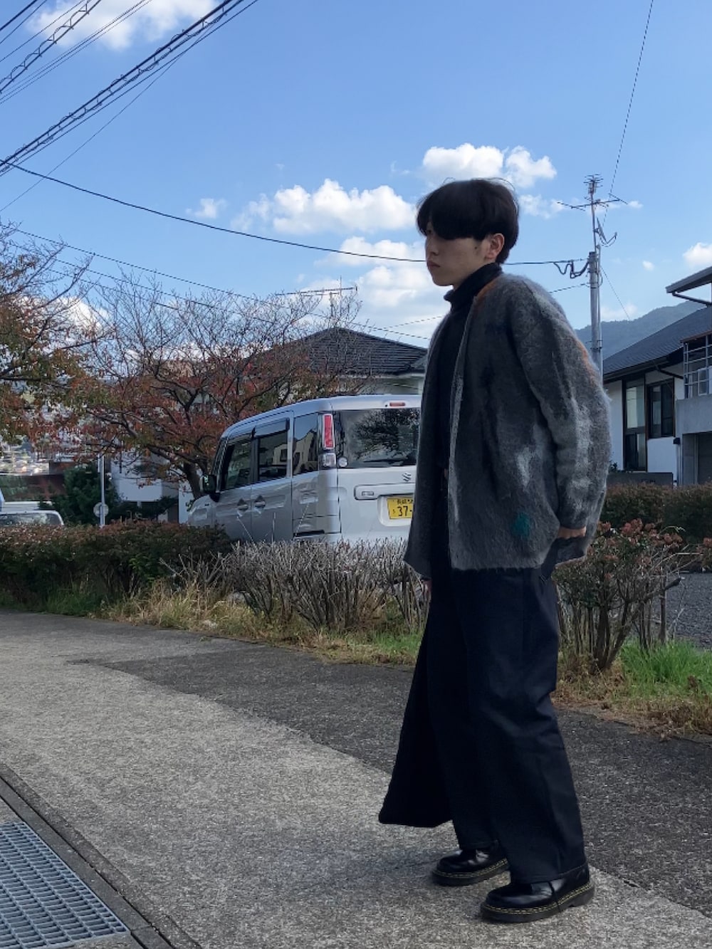 ブラック系のTシャツ/カットソー、グレー系のカーディガン/ボレロ、ブルー系のデニムパンツを着用したメンズの秋コーディネートの4枚目の写真