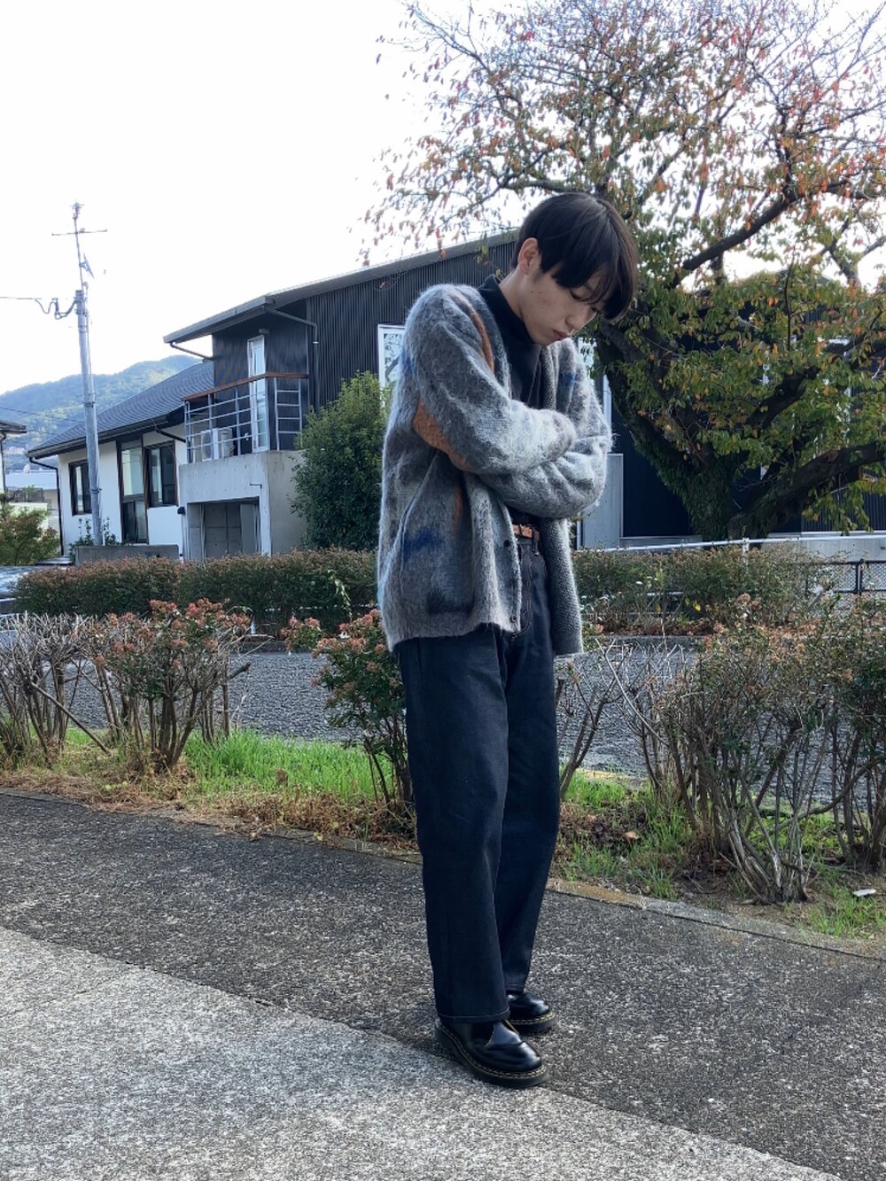 ブラック系のTシャツ/カットソー、グレー系のカーディガン/ボレロ、ブルー系のデニムパンツを着用したメンズの秋コーディネートの5枚目の写真