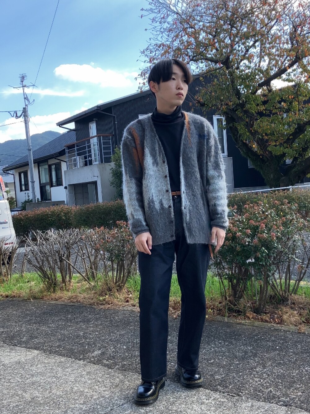 ブラック系のTシャツ/カットソー、グレー系のカーディガン/ボレロ、ブルー系のデニムパンツを着用したメンズの秋コーディネートの2枚目の写真