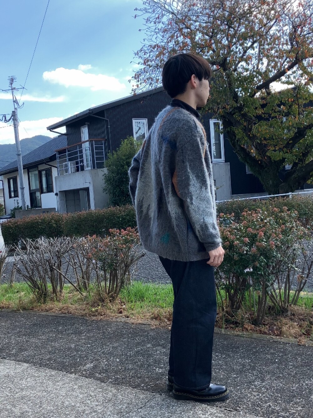 ブラック系のTシャツ/カットソー、グレー系のカーディガン/ボレロ、ブルー系のデニムパンツを着用したメンズの秋コーディネートの3枚目の写真