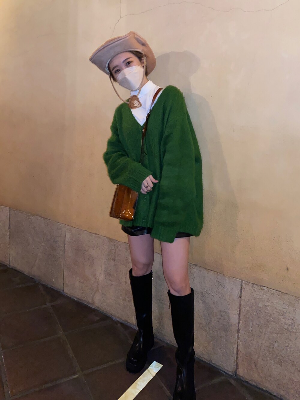 グリーン系のカーディガン/ボレロ、ブラック系のブーツ、その他のショルダーバッグを着用したレディースの秋コーディネートの2枚目の写真