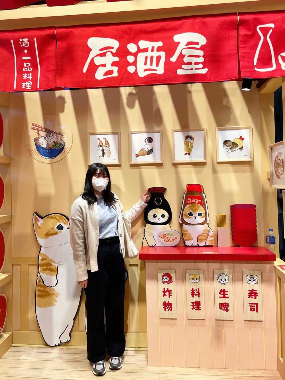 ブルー系のスラックス、ベージュ系のトップス、ホワイト系のトートバッグを着用したレディースの冬コーディネートの2枚目の写真