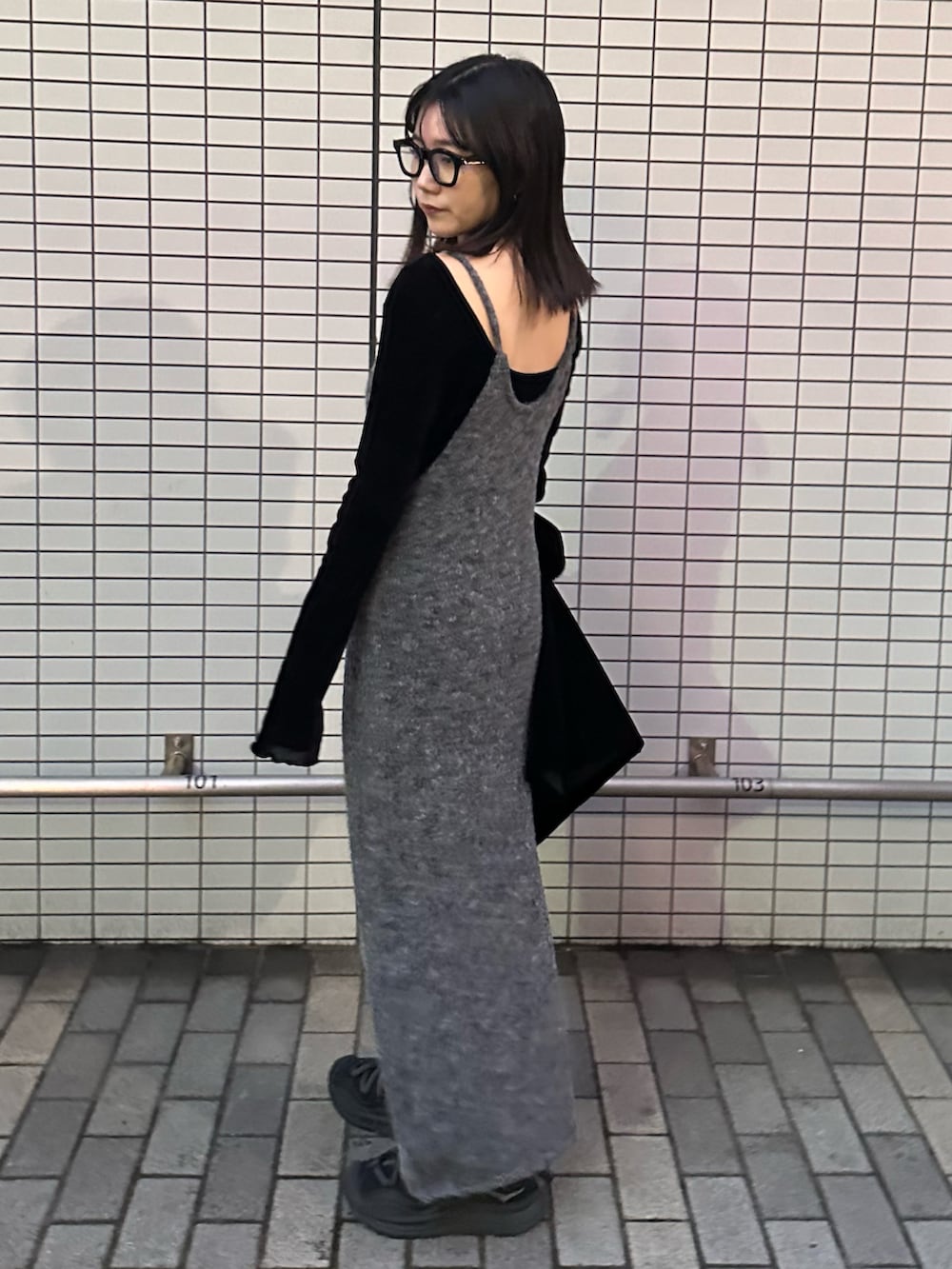 ブラック系のスニーカー、グレー系のワンピース、ブラック系のテーラードジャケットを着用したレディースの秋コーディネートの2枚目の写真