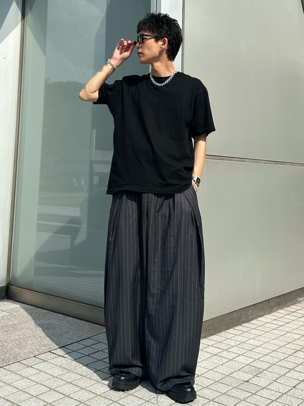 ブラック系のTシャツ/カットソー、グレー系のスラックス、シルバー系のネックレスを着用したメンズの夏コーディネートの2枚目の写真