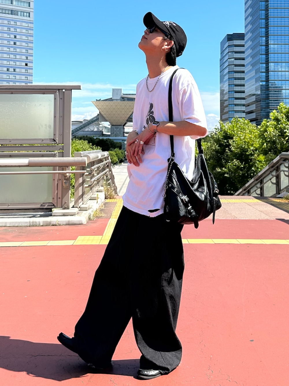 ホワイト系のTシャツ/カットソー、ブラック系のデニムパンツ、ブラック系のショルダーバッグを着用したメンズの夏コーディネートの2枚目の写真