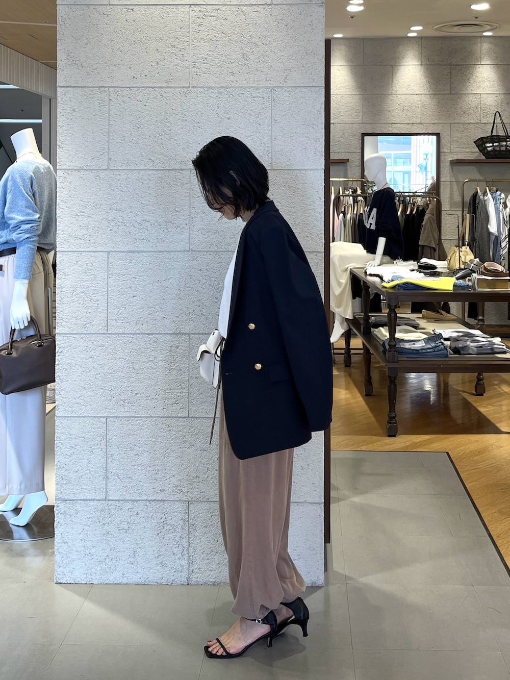 ホワイト系のニット/セーター、ブルー系のテーラードジャケット、ブラウン系のその他パンツを着用したレディースの春コーディネートの3枚目の写真