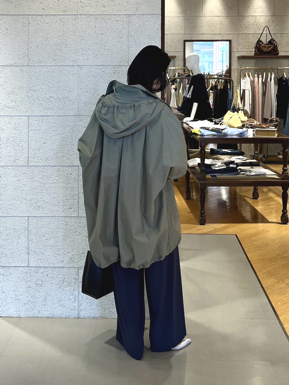 グレー系のスラックス、ブラック系のショルダーバッグ、シルバー系のその他シューズを着用したレディースの春コーディネートの4枚目の写真