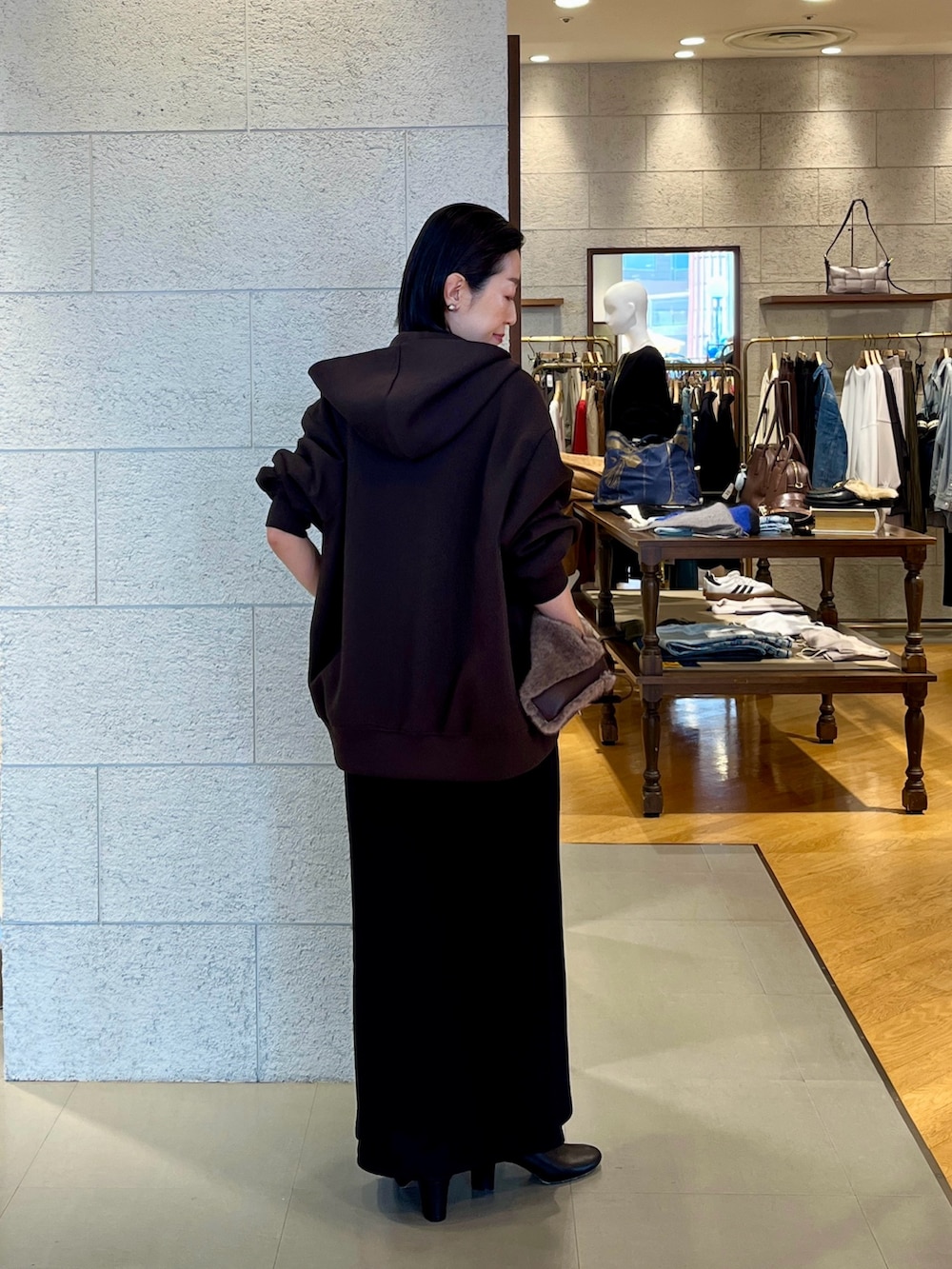 ブラウン系のハンドバッグ、ブラウン系のパーカー、ブラック系のワンピースを着用したレディースの秋コーディネートの4枚目の写真