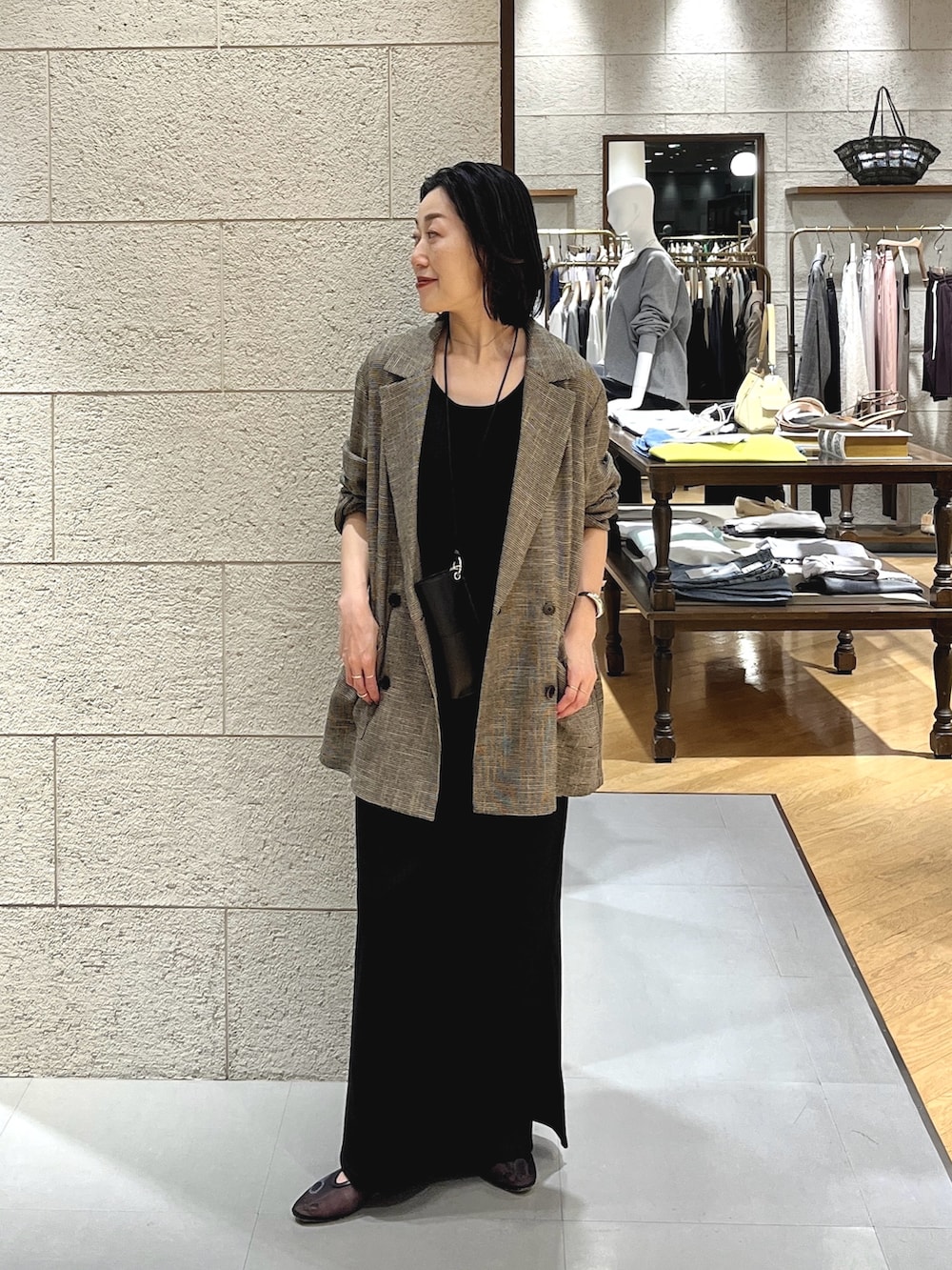 ブラウン系のテーラードジャケット、ブラック系のワンピース、ブラック系のその他シューズを着用したレディースの春コーディネートの2枚目の写真