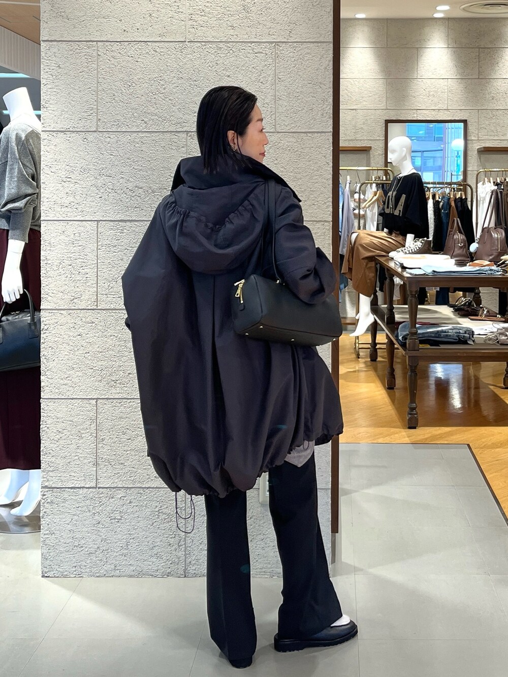 ブラック系のショルダーバッグ、ブラウン系のスウェット、グレー系のその他アウターを着用したレディースの秋コーディネートの4枚目の写真