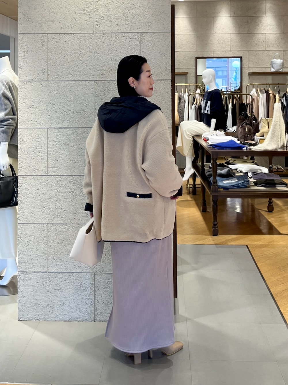 ベージュ系のワンピース、ホワイト系のニット/セーター、ベージュ系のその他アウターを着用したレディースの冬コーディネートの4枚目の写真