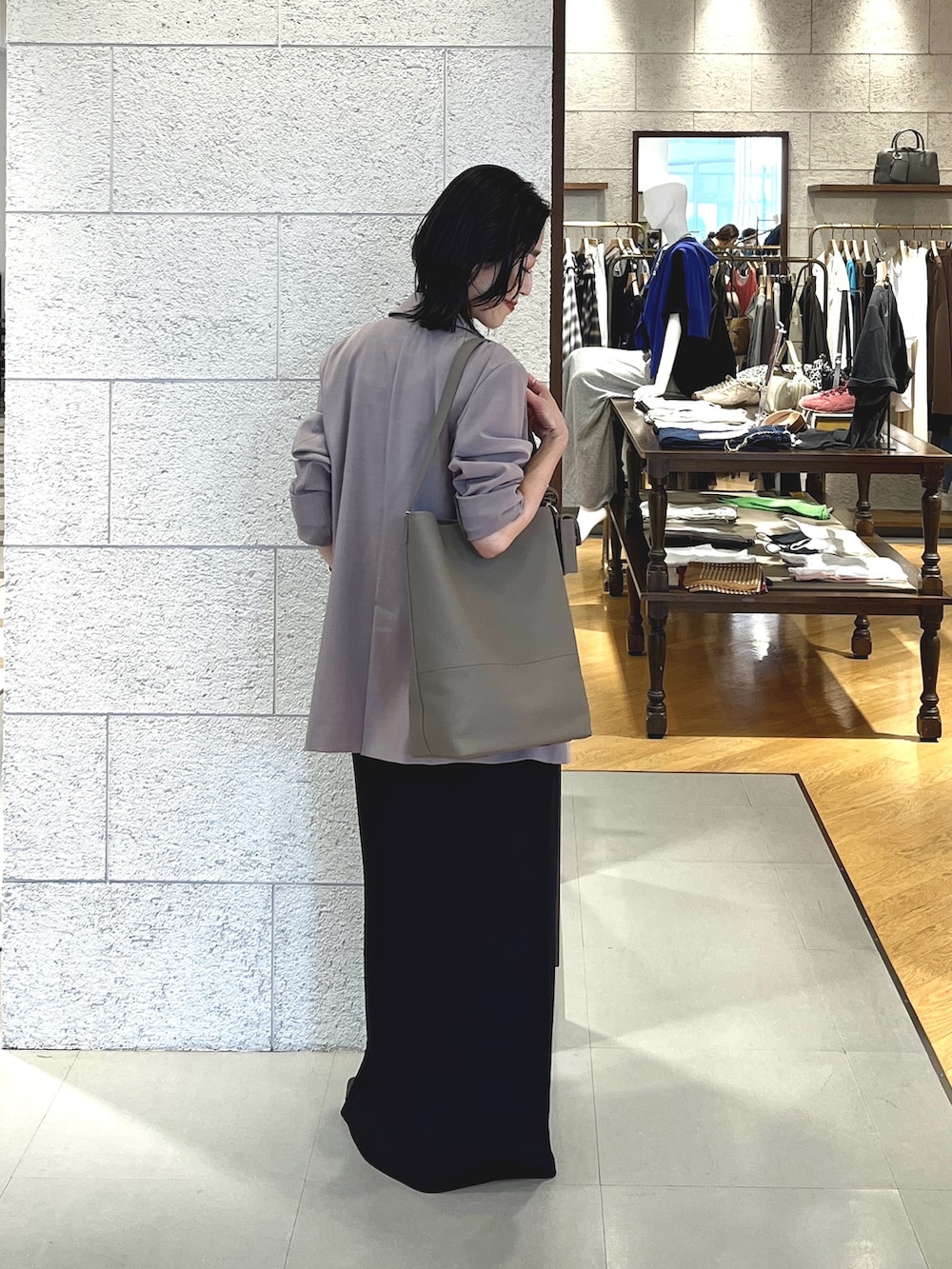グレー系のトートバッグ、ブラック系のパンプス、ブラック系のワンピースを着用したレディースの秋コーディネートの3枚目の写真