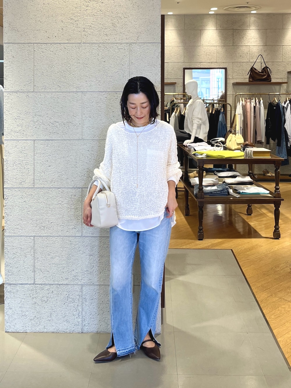 ブラウン系のその他シューズ、ホワイト系のボストンバッグ、ブルー系のデニムパンツを着用したレディースの春コーディネートの2枚目の写真