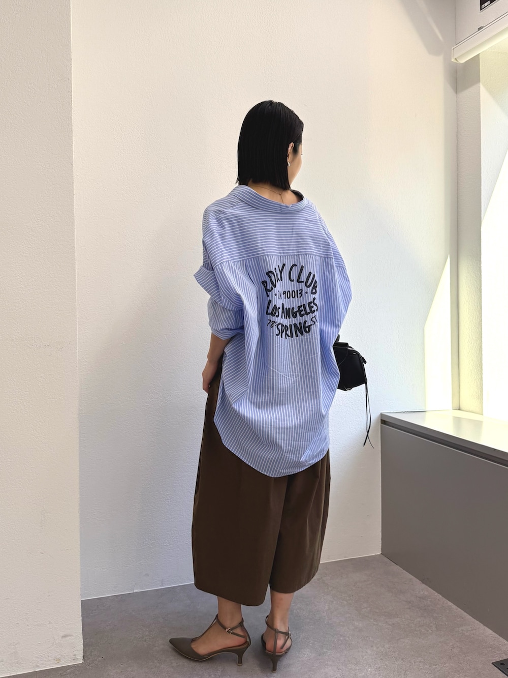 ブルー系のシャツ/ブラウス、ブラウン系のその他パンツ、グレー系のその他シューズを着用したレディースの冬コーディネートの2枚目の写真