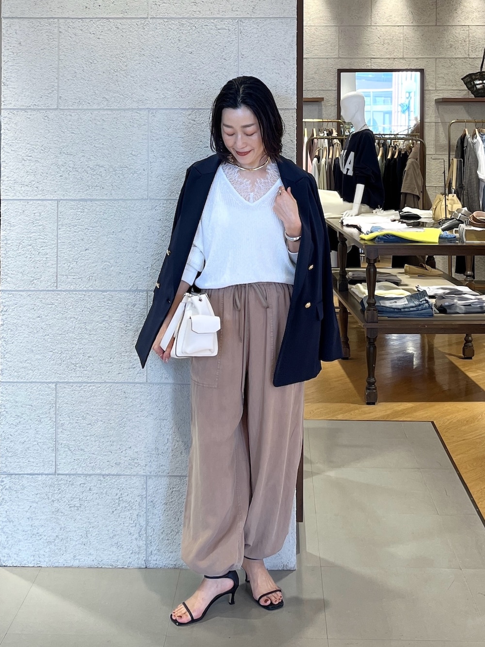 ホワイト系のニット/セーター、ブルー系のテーラードジャケット、ブラウン系のその他パンツを着用したレディースの春コーディネートの2枚目の写真