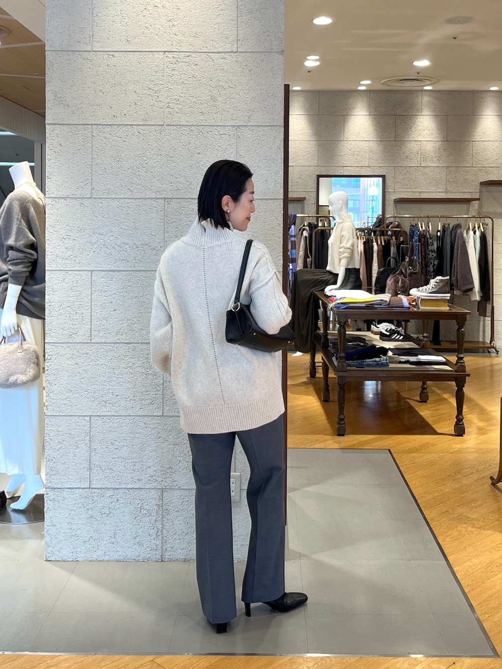 ホワイト系のニット/セーター、ブラック系のハンドバッグ、グレー系のその他パンツを着用したレディースの秋コーディネートの4枚目の写真