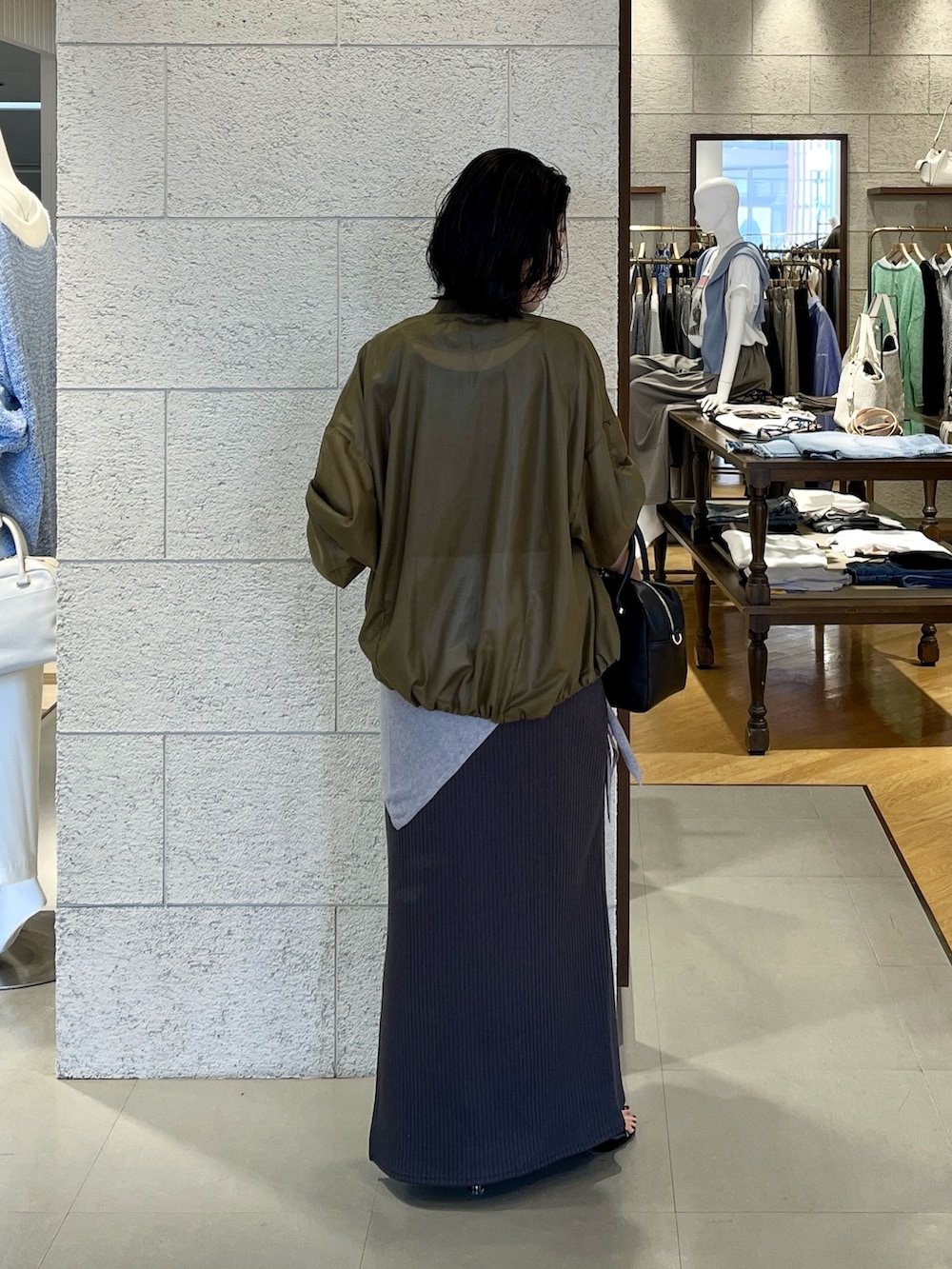 グリーン系のブルゾン、グレー系のワンピース、ブラック系のその他シューズを着用したレディースの春コーディネートの4枚目の写真