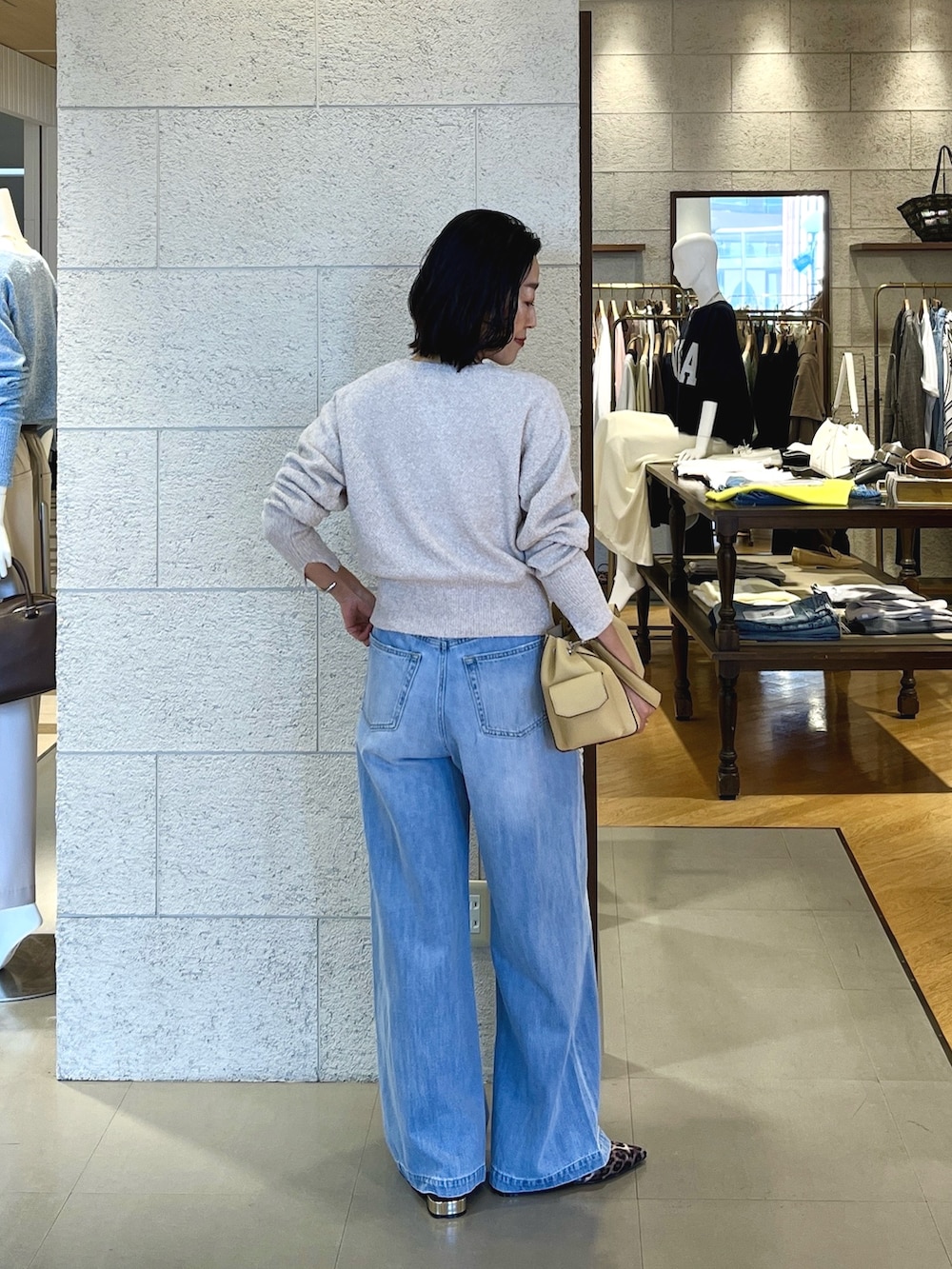 ベージュ系のその他シューズ、ベージュ系のショルダーバッグ、ブルー系のデニムパンツを着用したレディースの春コーディネートの3枚目の写真