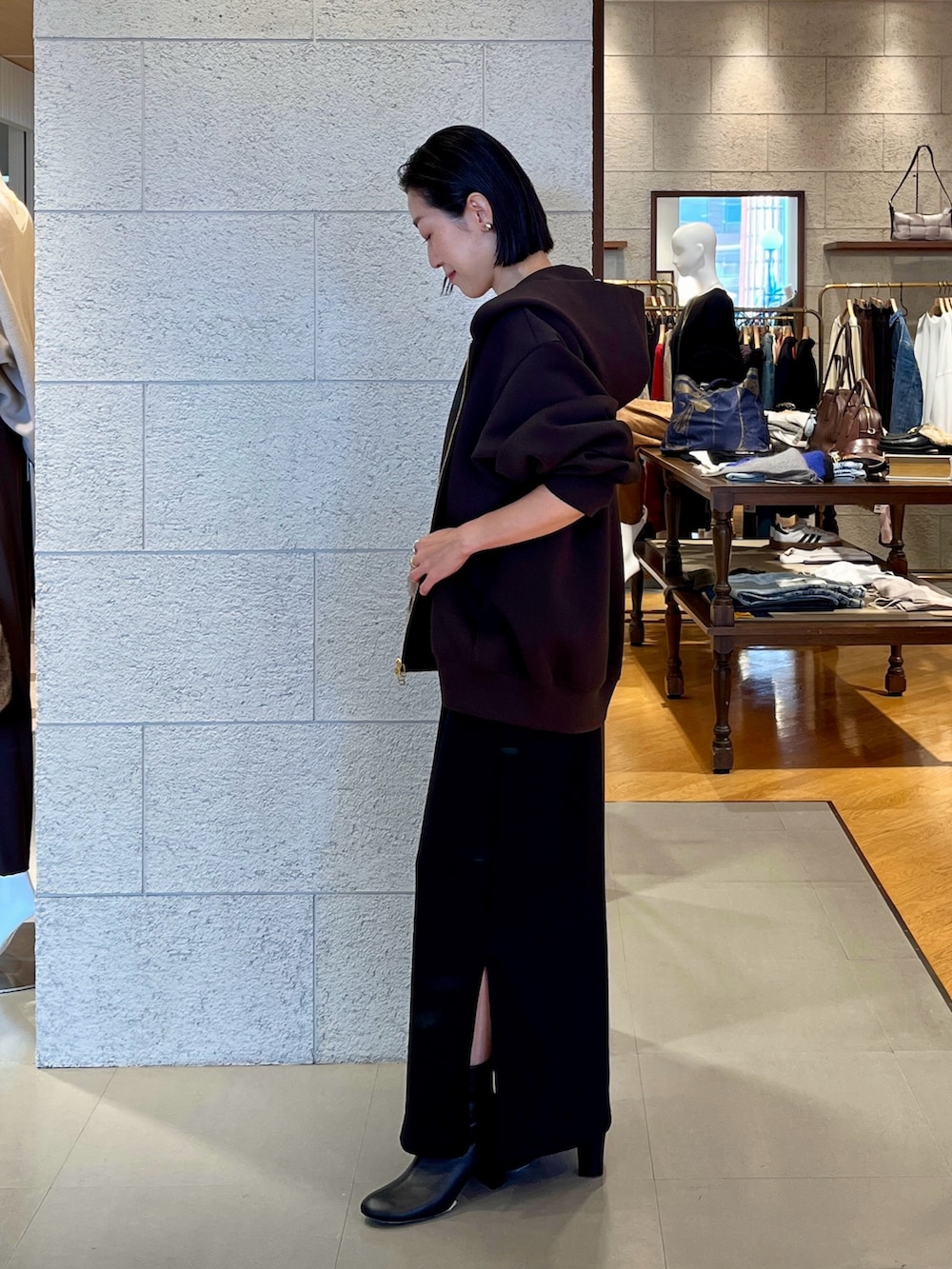 ブラウン系のハンドバッグ、ブラウン系のパーカー、ブラック系のワンピースを着用したレディースの秋コーディネートの3枚目の写真