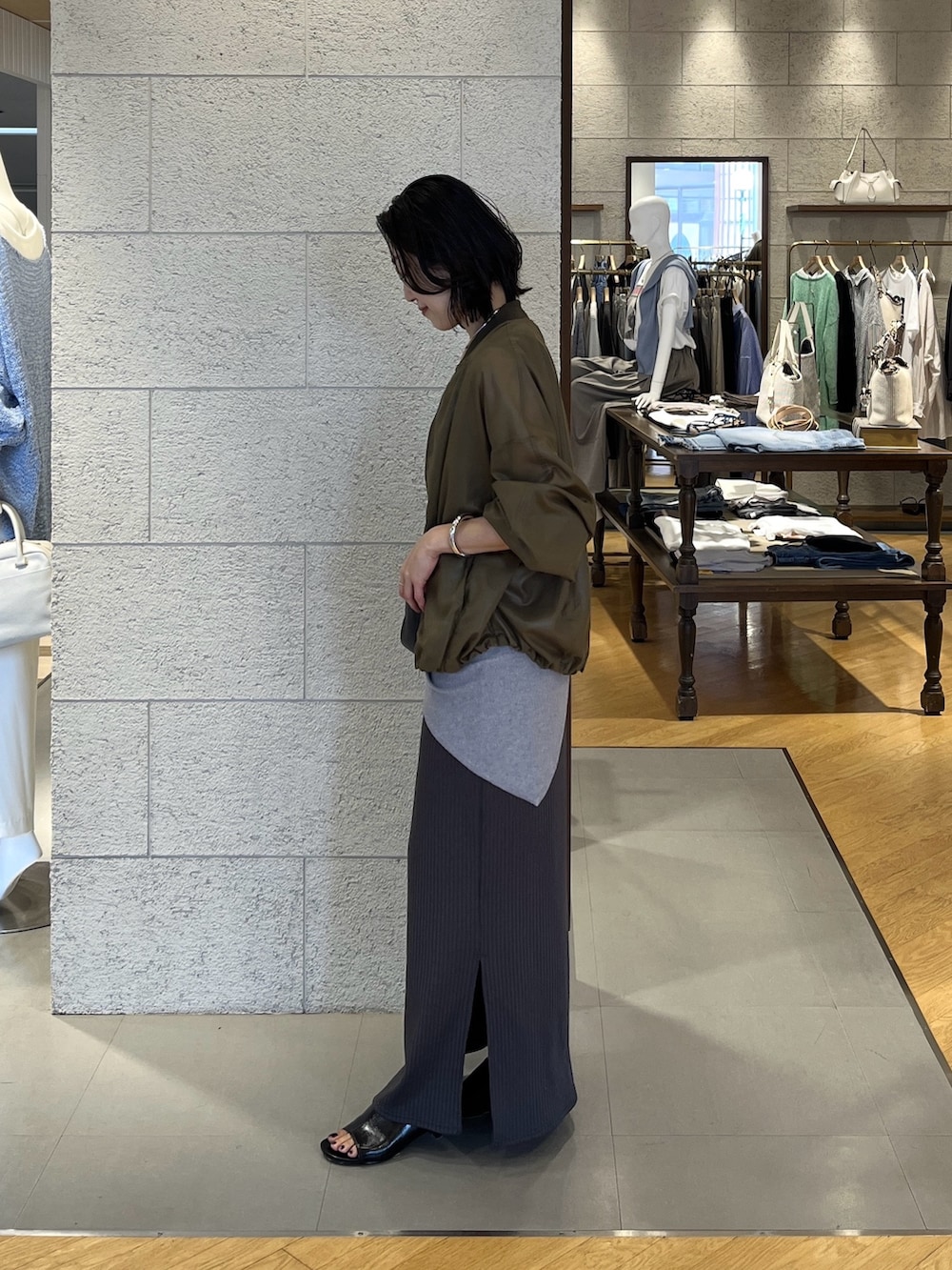 グリーン系のブルゾン、グレー系のワンピース、ブラック系のその他シューズを着用したレディースの春コーディネートの3枚目の写真