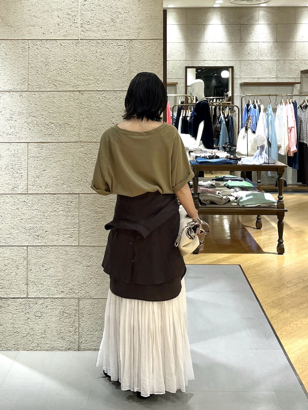 ブラウン系のシャツ/ブラウス、ホワイト系のスカート、ブラック系のサンダルを着用したレディースの夏コーディネートの2枚目の写真