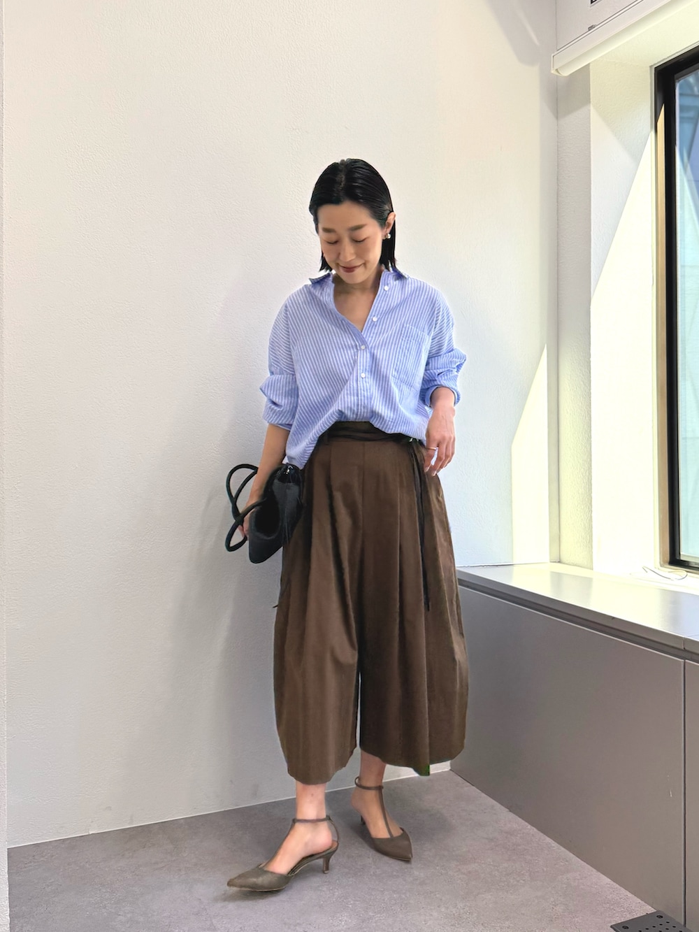 ブルー系のシャツ/ブラウス、ブラウン系のその他パンツ、グレー系のその他シューズを着用したレディースの冬コーディネートの3枚目の写真