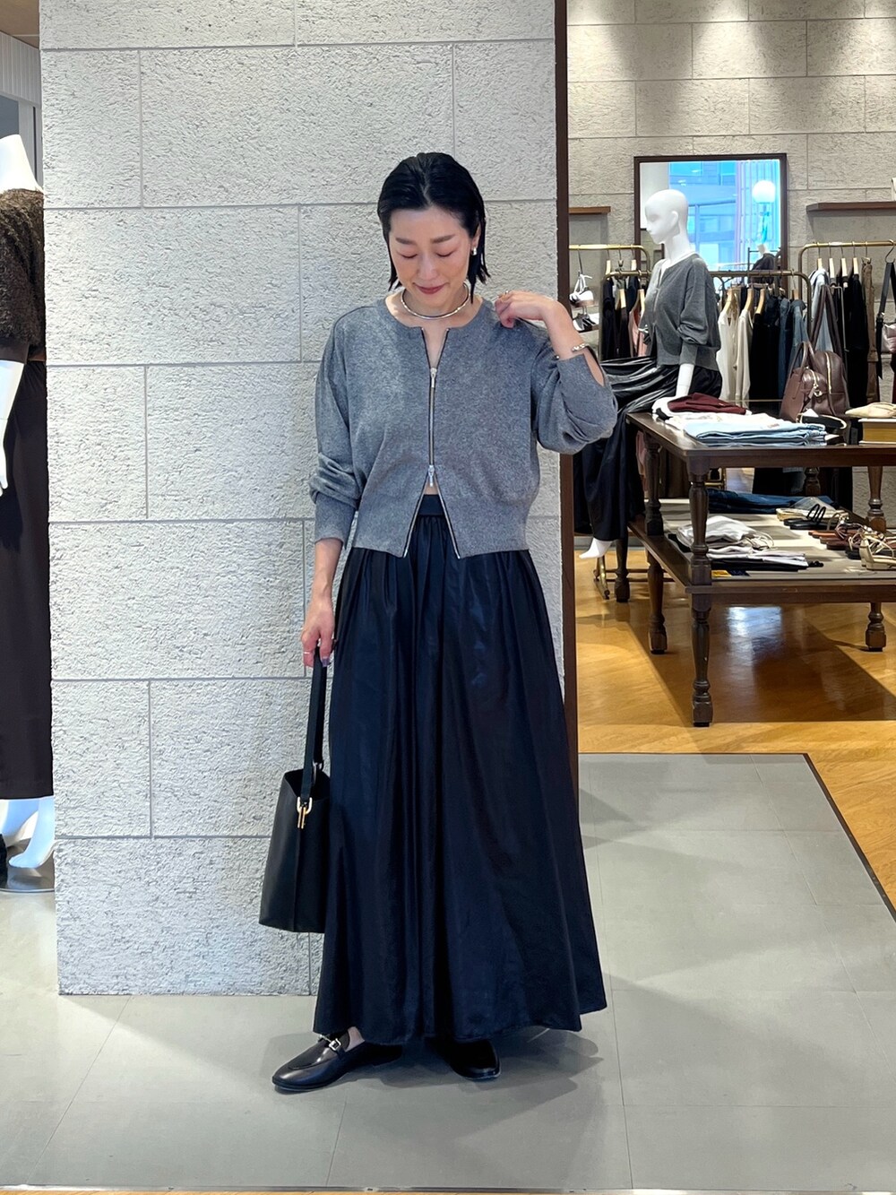 ブラック系のスカート、ブラック系のローファー、ブラック系のカーディガン/ボレロを着用したレディースの夏コーディネートの2枚目の写真