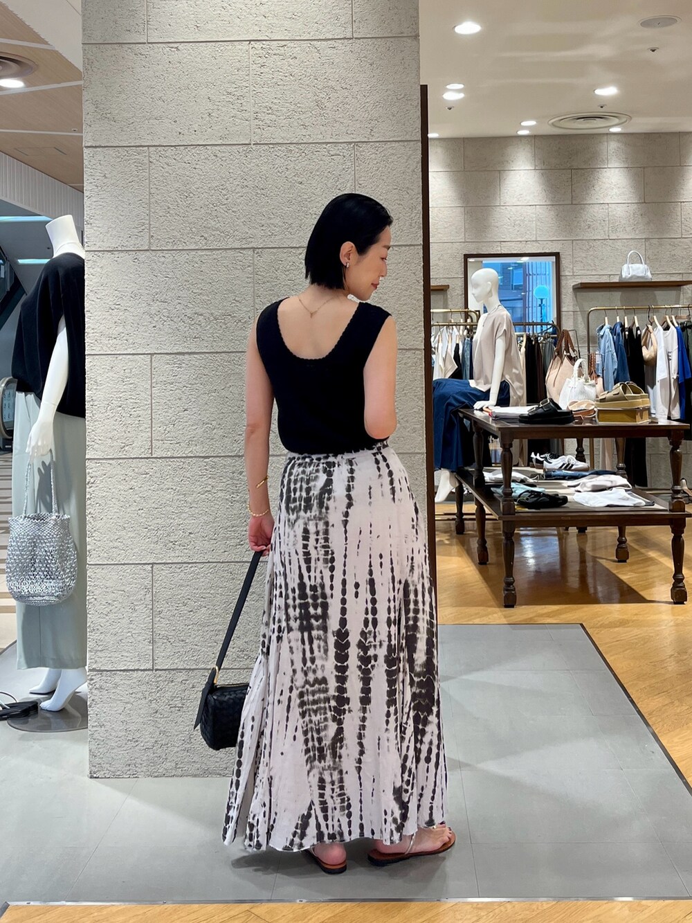 ブラック系のニット/セーター、ブラック系のスカート、ブラック系のベストを着用したレディースの夏コーディネートの4枚目の写真