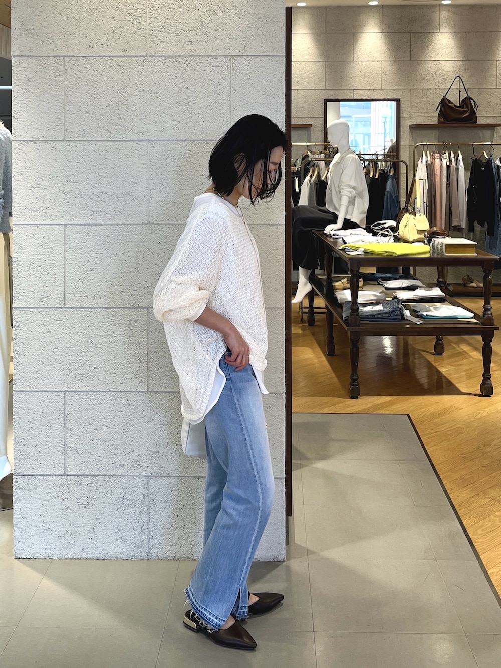 ブラウン系のその他シューズ、ホワイト系のボストンバッグ、ブルー系のデニムパンツを着用したレディースの春コーディネートの3枚目の写真