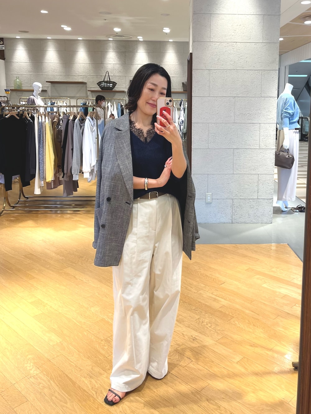 ブルー系のニット/セーター、ブラック系のテーラードジャケット、ホワイト系のチノパンツを着用したレディースの春コーディネートの5枚目の写真