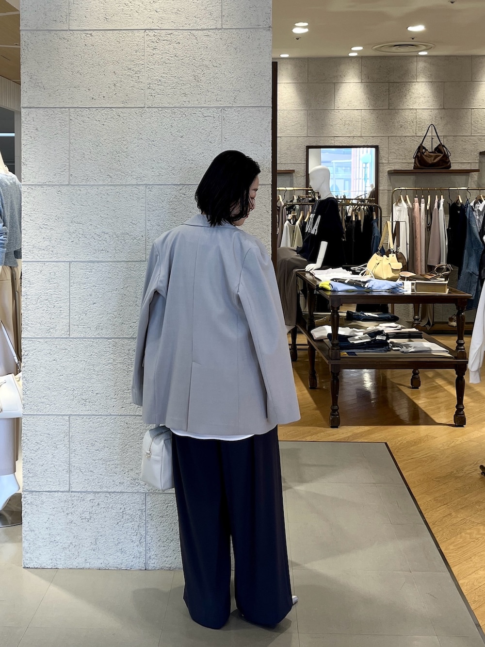 グレー系のスラックス、シルバー系のその他シューズ、ホワイト系のボストンバッグを着用したレディースの春コーディネートの3枚目の写真