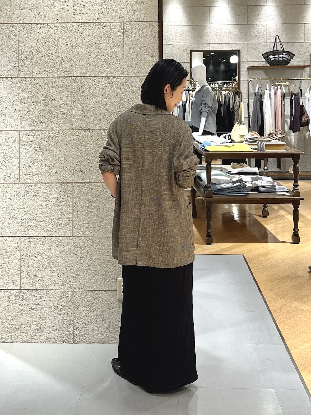 ブラウン系のテーラードジャケット、ブラック系のワンピース、ブラック系のその他シューズを着用したレディースの春コーディネートの3枚目の写真