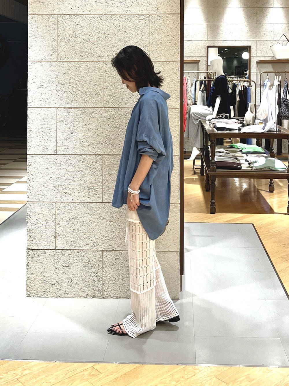 グレー系のトートバッグ、ホワイト系のその他パンツ、ブルー系のシャツ/ブラウスを着用したレディースの夏コーディネートの3枚目の写真