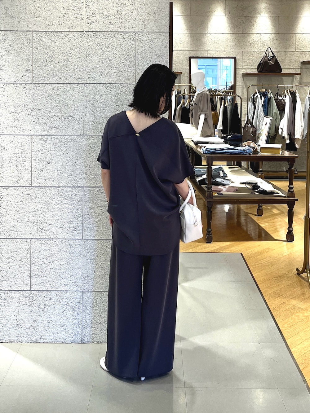 グレー系のTシャツ/カットソー、ホワイト系のその他シューズ、ホワイト系のボストンバッグを着用したレディースの春コーディネートの3枚目の写真