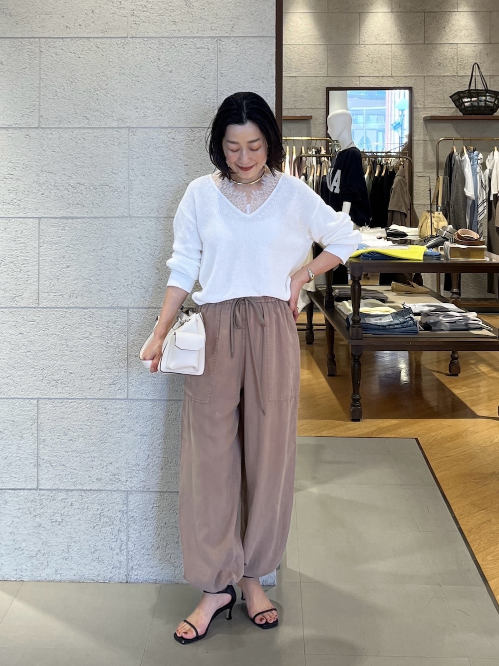 ホワイト系のニット/セーター、ブルー系のテーラードジャケット、ブラウン系のその他パンツを着用したレディースの春コーディネートの4枚目の写真