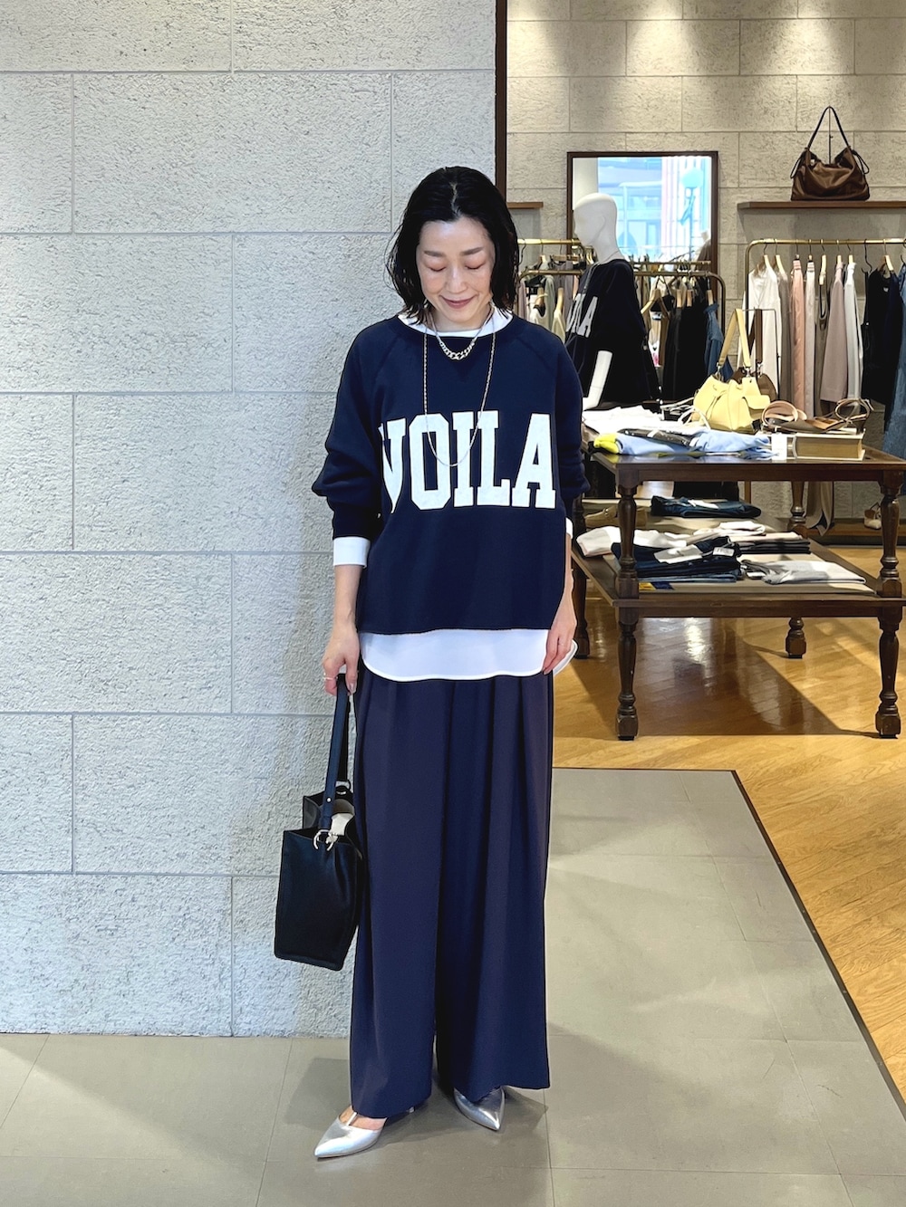 グレー系のスラックス、ブラック系のショルダーバッグ、シルバー系のその他シューズを着用したレディースの春コーディネートの5枚目の写真