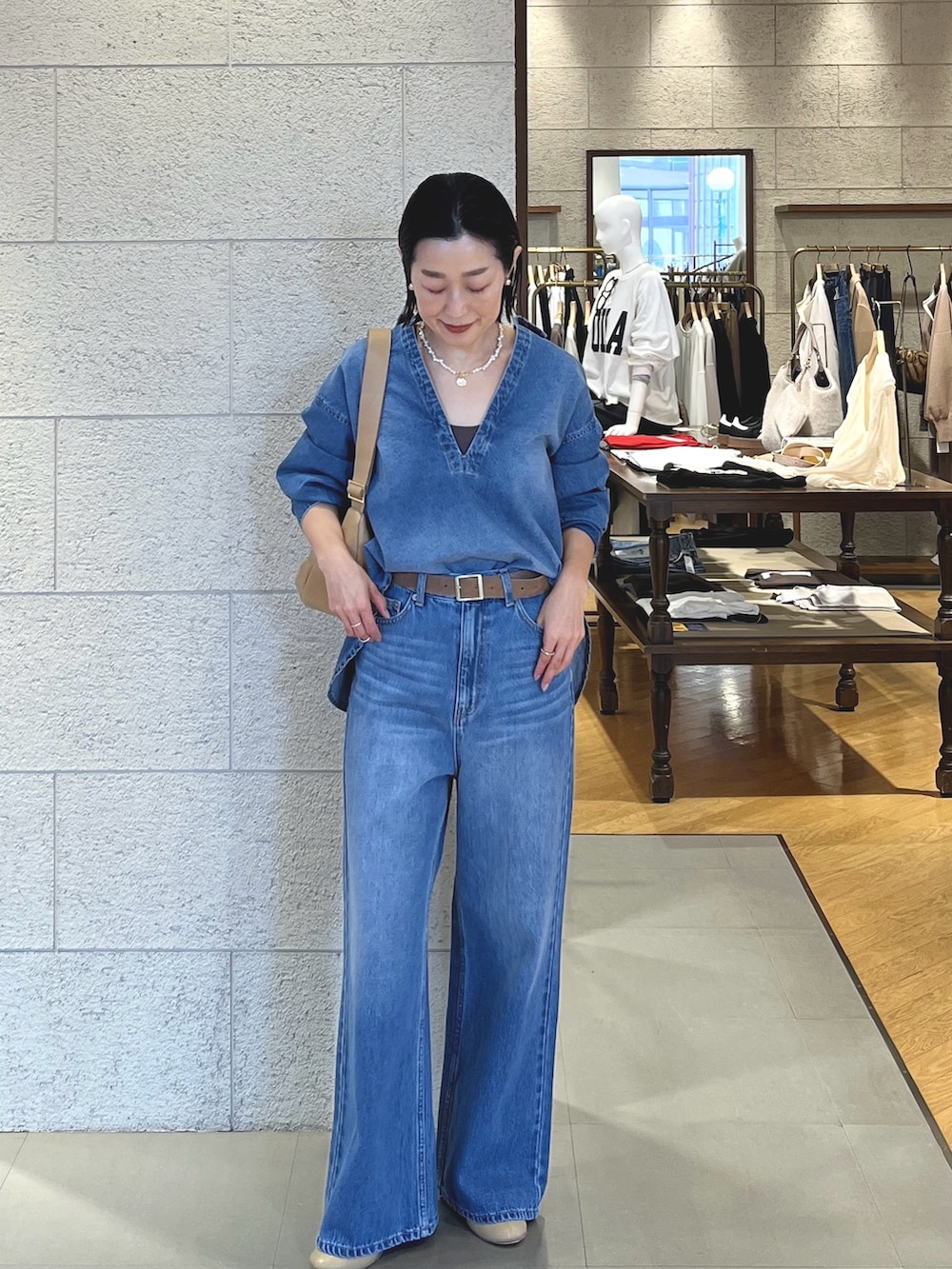 ベージュ系のショルダーバッグ、ブルー系のシャツ/ブラウス、グレー系のTシャツ/カットソーを着用したレディースの冬コーディネートの2枚目の写真