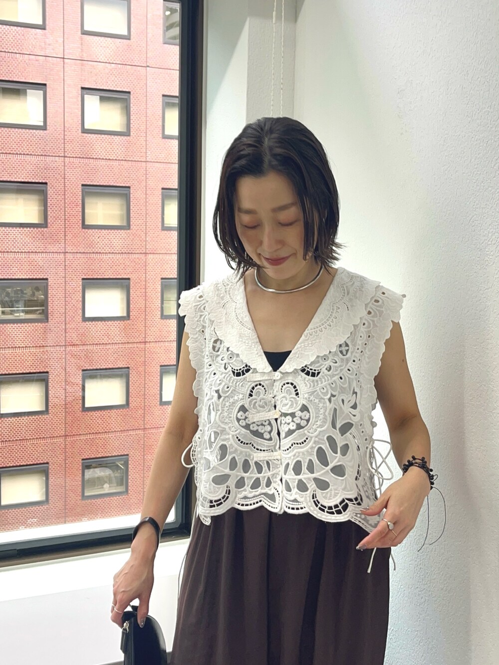 ブラウン系のその他パンツ、ブラウン系のサンダル、ホワイト系のベストを着用したレディースの夏コーディネートの2枚目の写真
