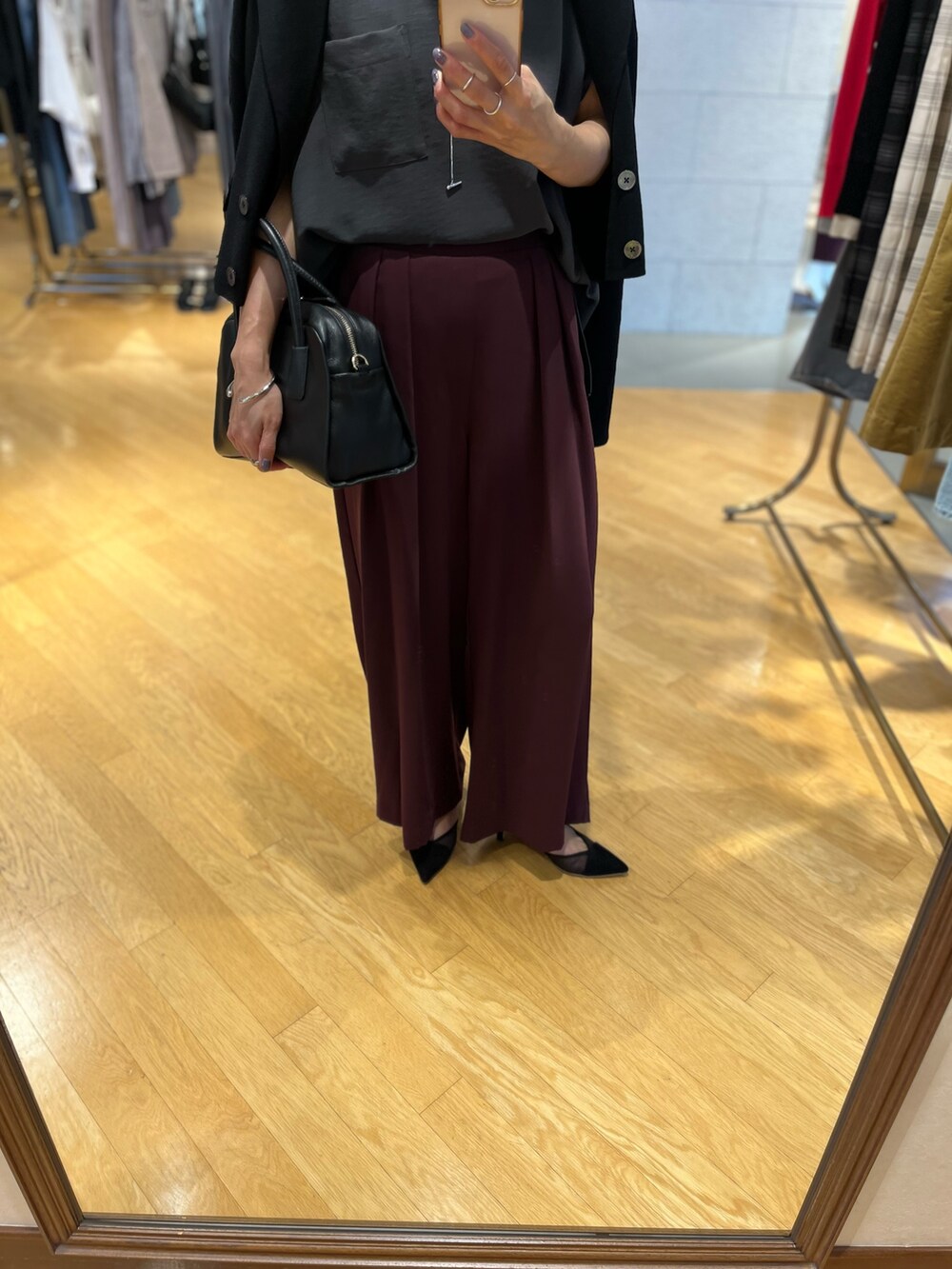 ブラック系のパンプス、ブラック系のボストンバッグ、ブラック系のテーラードジャケットを着用したレディースの夏コーディネートの3枚目の写真