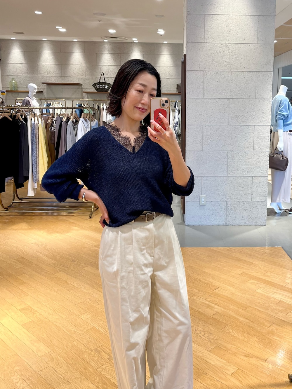 ホワイト系のチノパンツ、ベージュ系のトートバッグ、ブルー系のニット/セーターを着用したレディースの春コーディネートの4枚目の写真